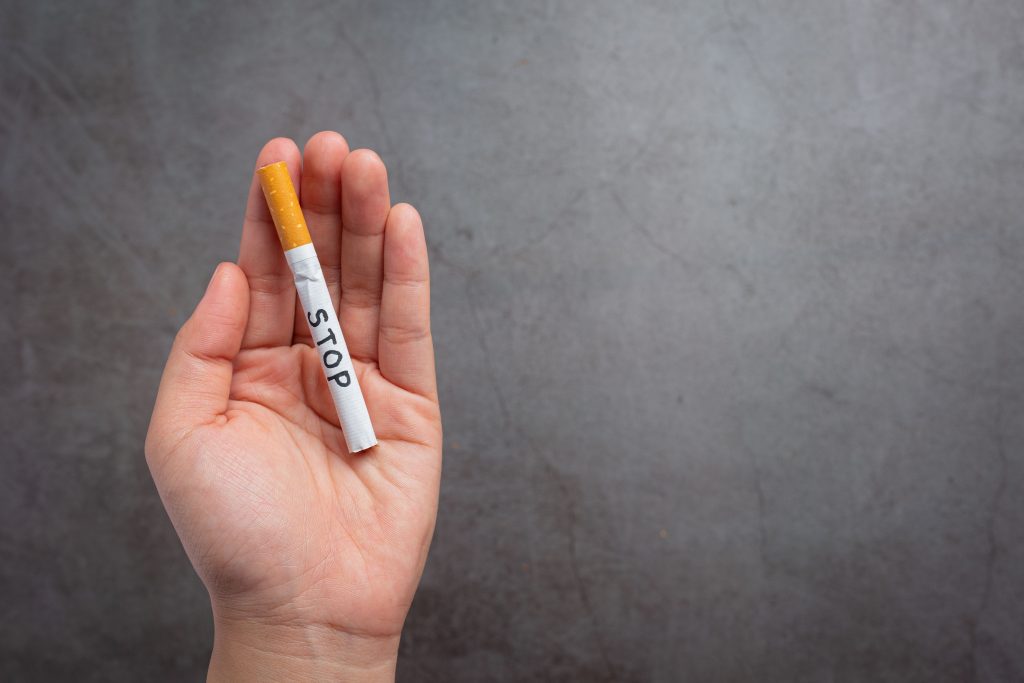 human_hand_holding_cigarette_world_no_tobacco_day_concept_42d77f41a6